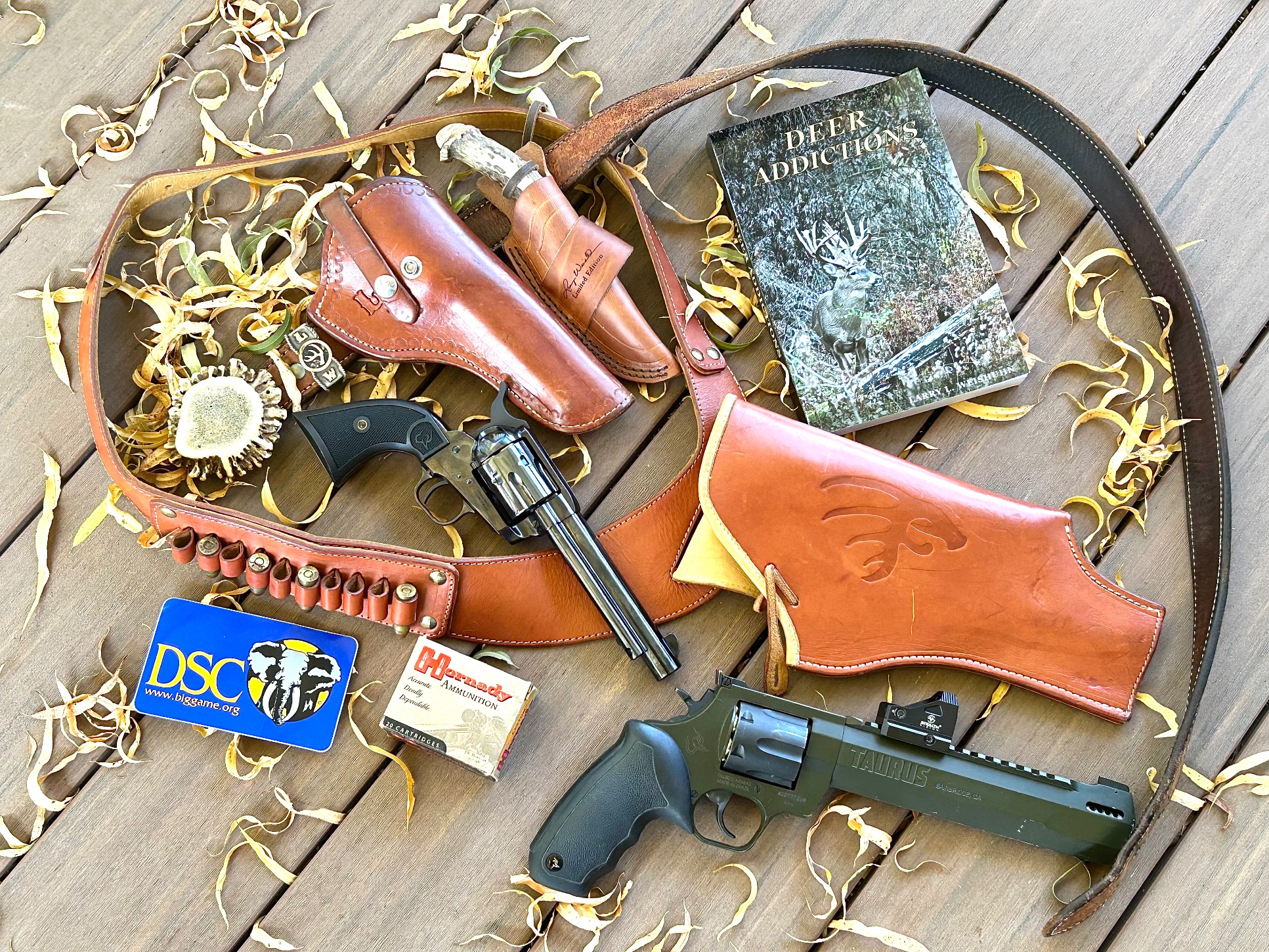 taurus-deputy-raging-hunter-carry-collection Flat lay of Larry Weishuhn's handgun carry collection: Taurus Deputy and Raging Hunter revolvers with leather holsters